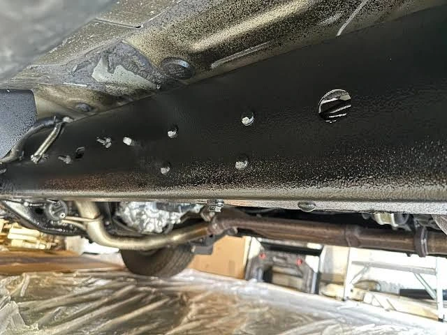 Fresh rustproofing coating applied to the underside and frame rail of a pickup truck